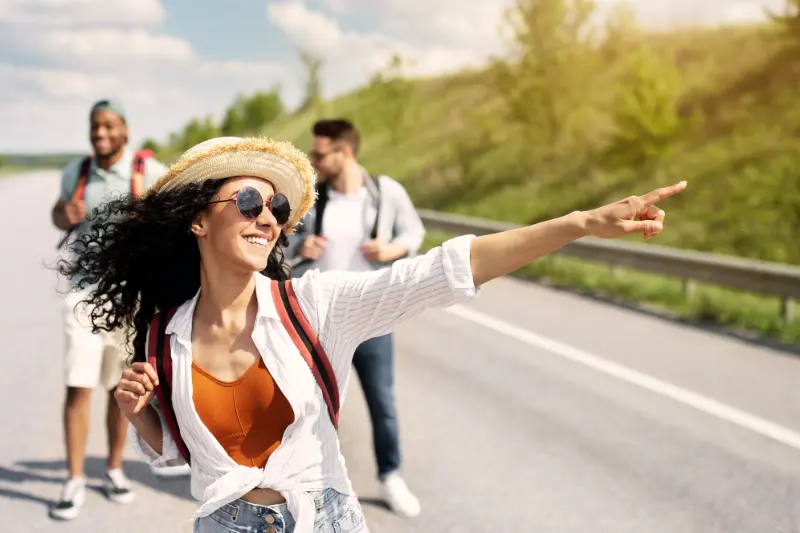 Young friends walking down a road and pointing